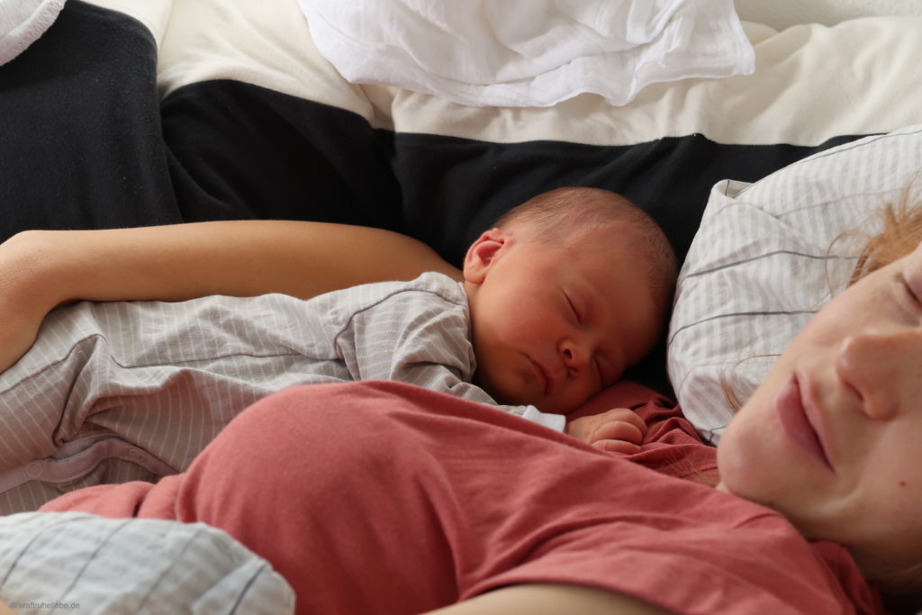 Ein neugeborenes Baby liegt im Arm seiner Mutter
