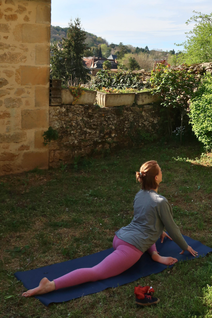 Beckenbodenentspannung: eine Frau in pinken Yogaleggings übt die Yogaposition Taube