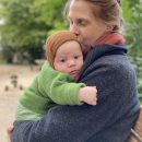 Eine Frau hält ein etwa zwei Monate altes Baby im Arm.